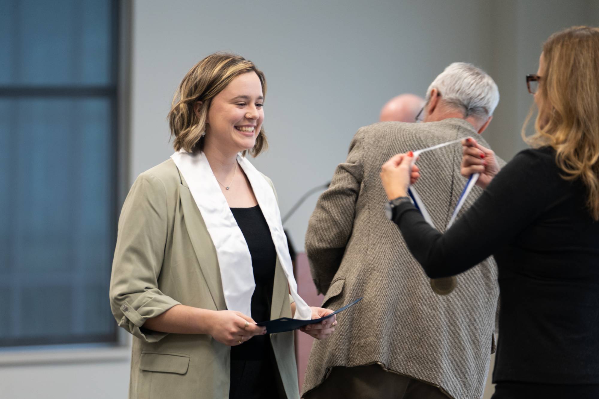 Honors graduate smiles while receiving their medallion